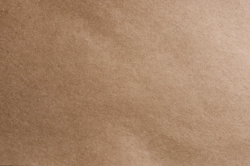 Close-up flat lay of smooth matte brown kraft paper surface