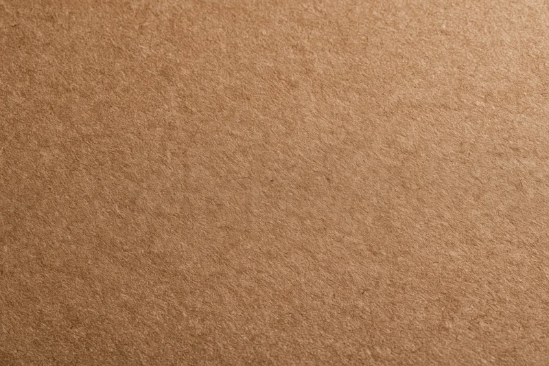 Close-up of smooth matte brown kraft paper surface in flat lay arrangement
