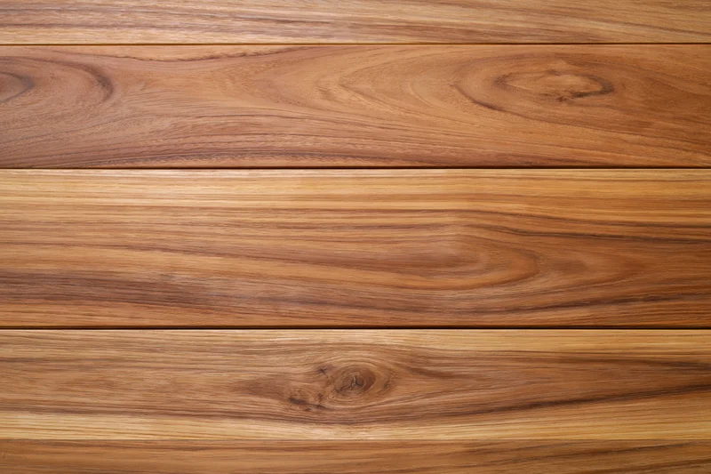 Close-up of smooth teak wood planks arranged horizontally showing natural grain and warm brown tones