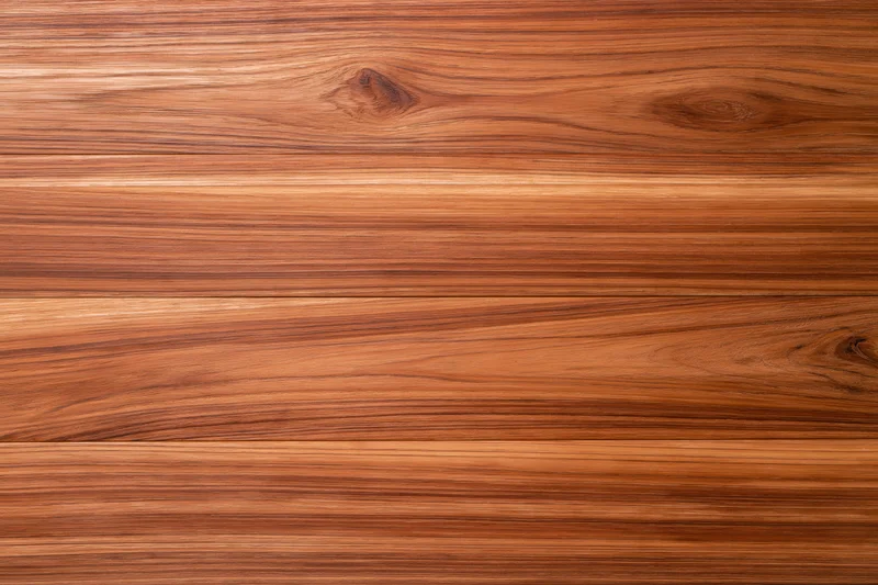 Close-up of smooth teak wood surface with horizontal grain pattern