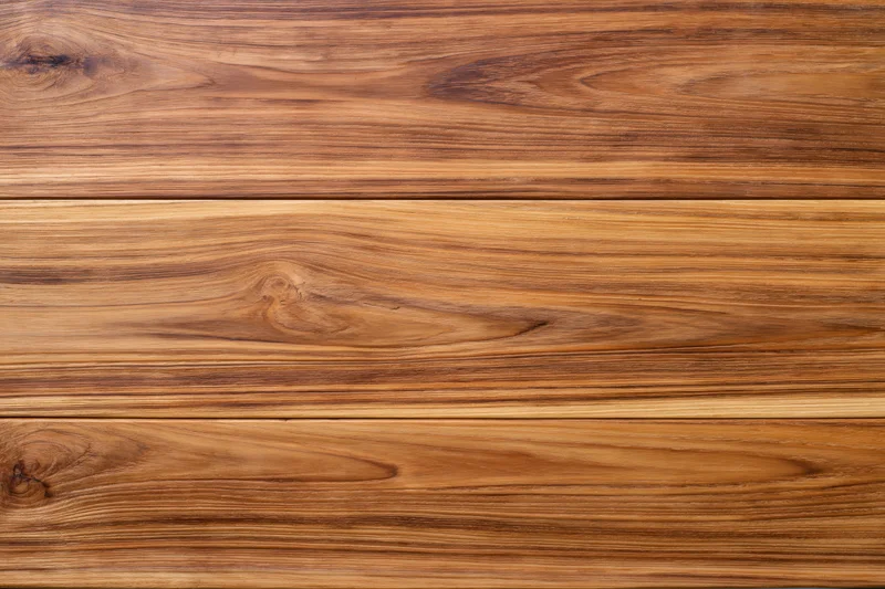 Close-up of smooth teak wood surface with horizontal grain pattern