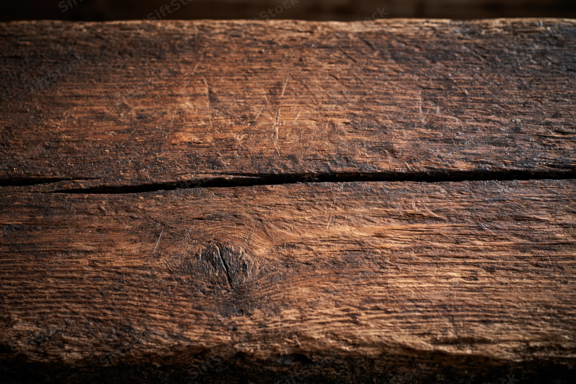 Close-up of weathered wooden planks with visible grain and knots filling the frame