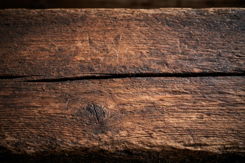 Close-up of weathered wooden planks with visible grain and knots filling the frame