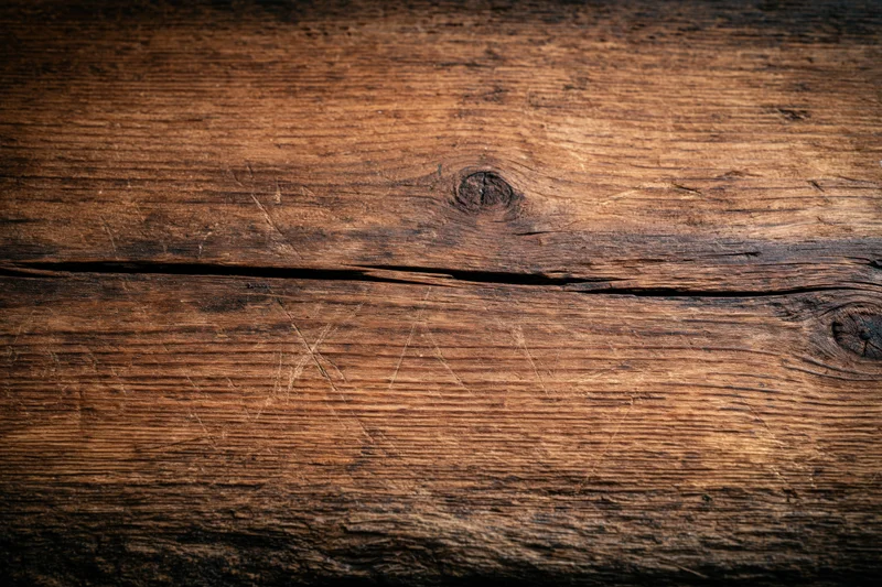 Close-up of weathered wooden surface with visible grain and knots, flat lay arrangement