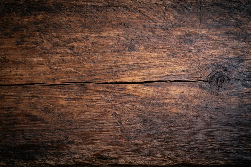 Close-up of weathered wooden surface with visible grain and knots, flat lay view