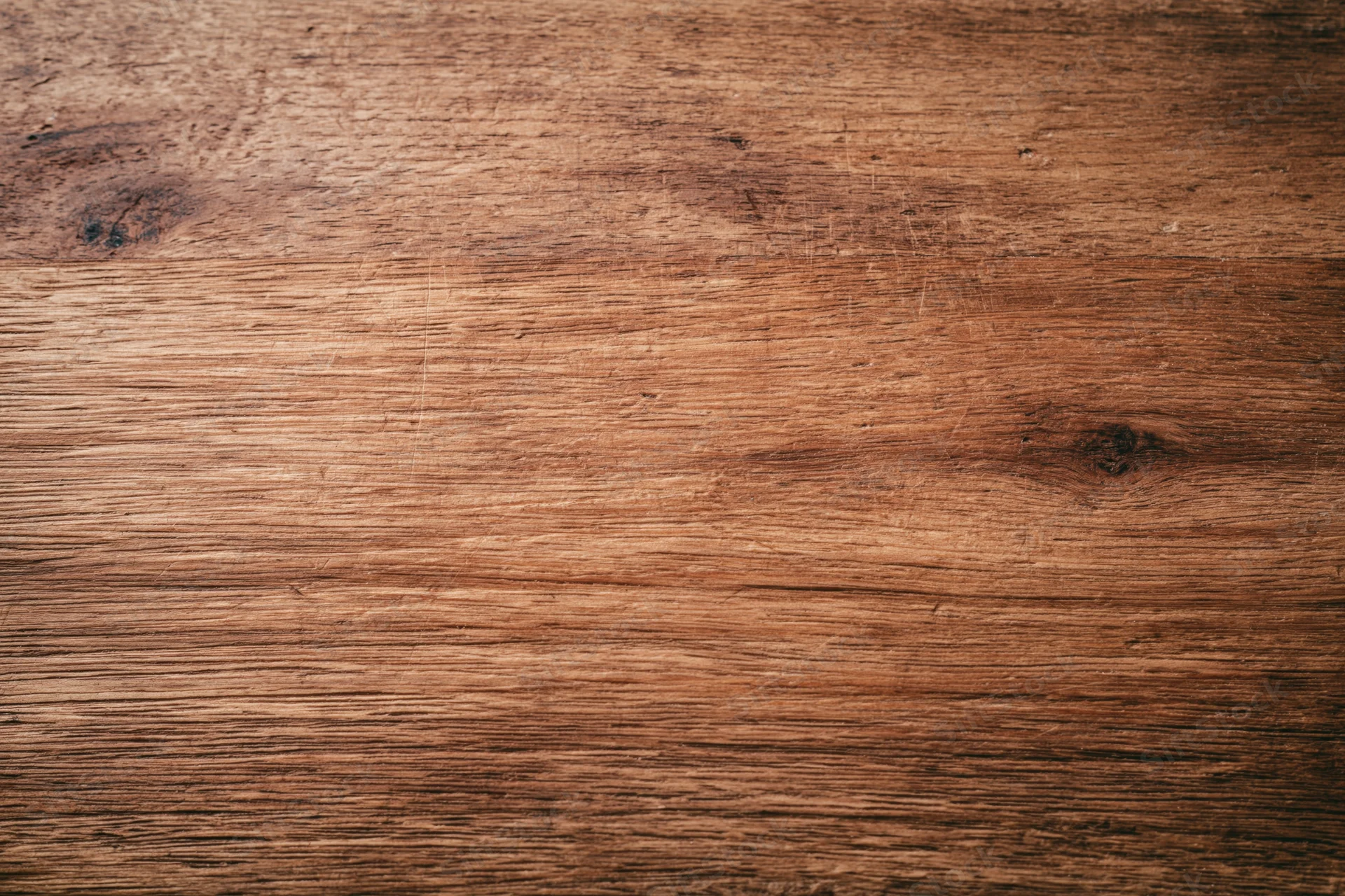 Close-up of a worn wooden surface with visible grain and knots filling the frame