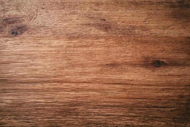 Close-up of a worn wooden surface with visible grain and knots filling the frame