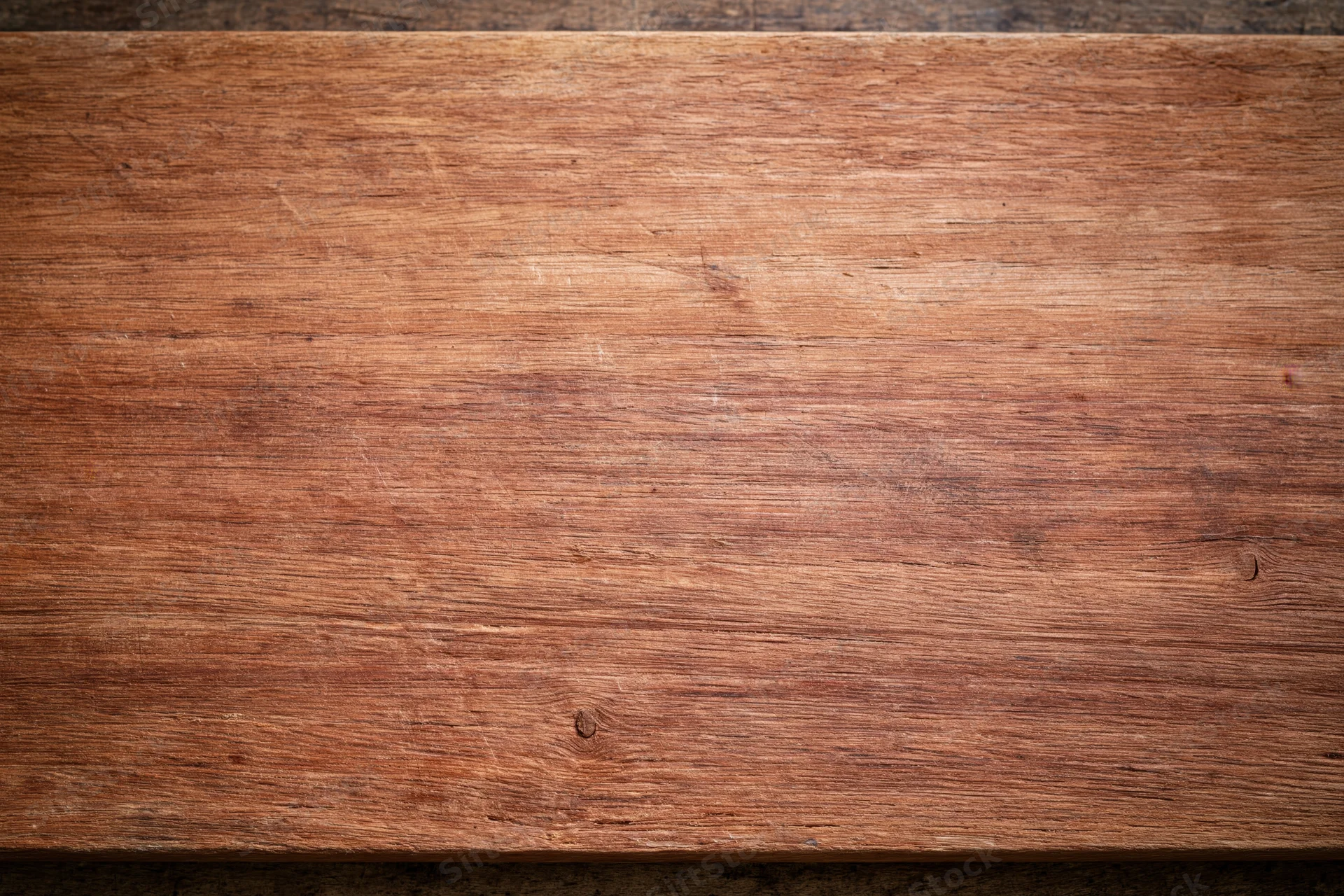Close-up of a worn wooden surface with visible grain and texture filling the frame