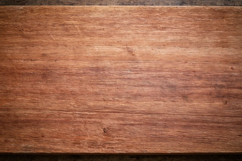 Close-up of a worn wooden surface with visible grain and texture filling the frame