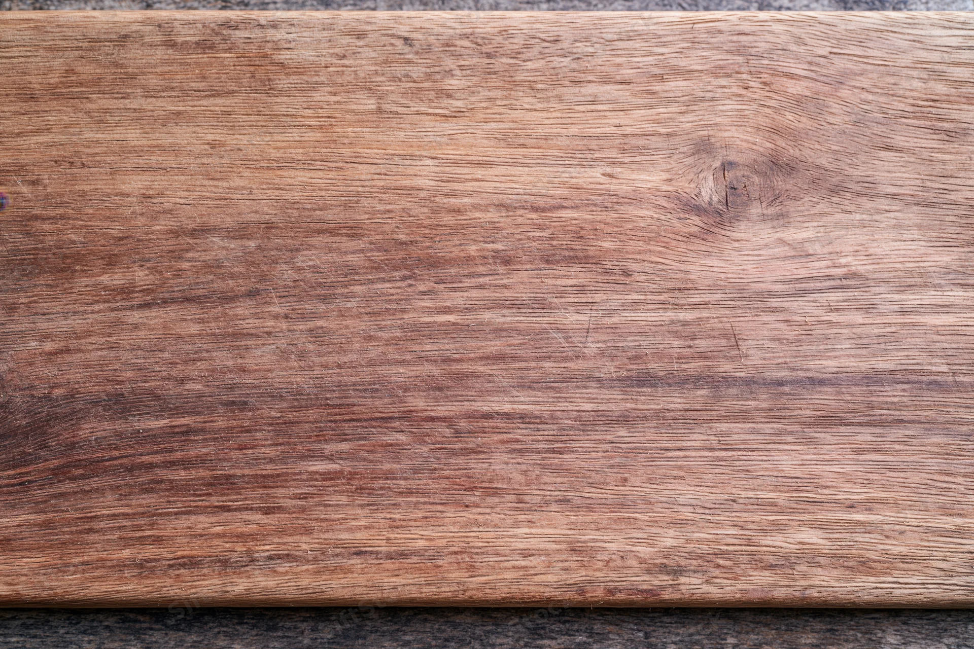 Close-up of a worn wooden surface with visible grain and knots, flat lay view