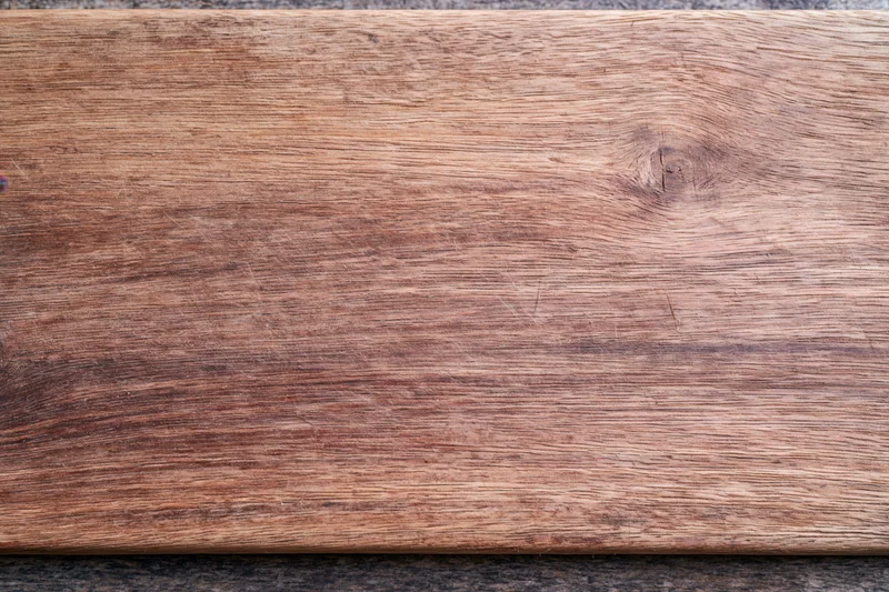 Close-up of a worn wooden surface with visible grain and knots, flat lay view
