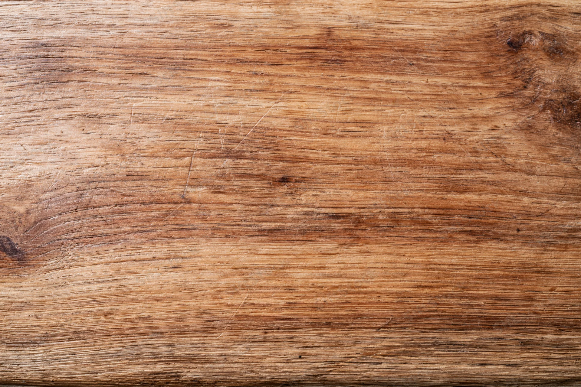 Close-up of a worn wooden surface with visible grain and texture filling the frame