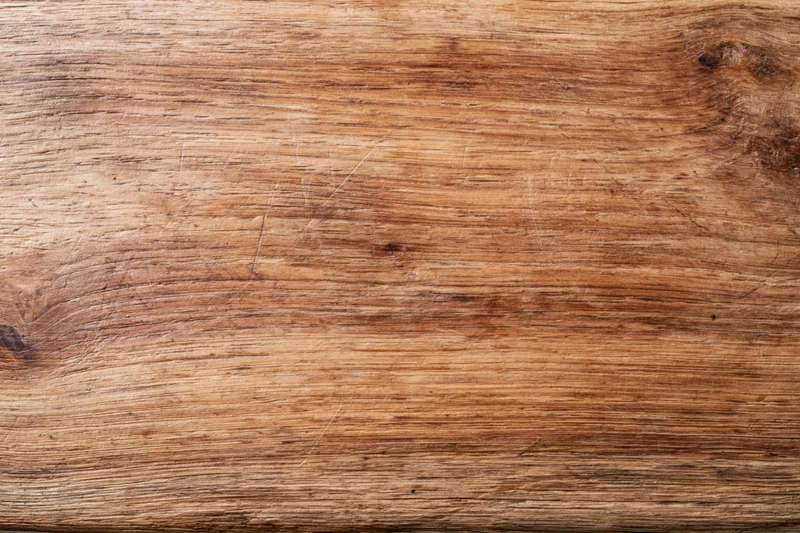 Close-up of a worn wooden surface with visible grain and texture filling the frame