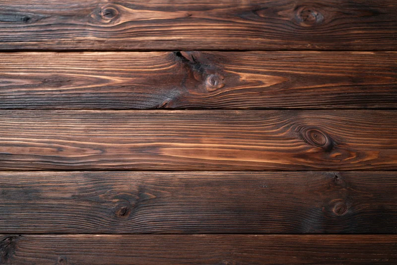 Close-up of aged dark walnut wooden planks arranged horizontally as a textured surface