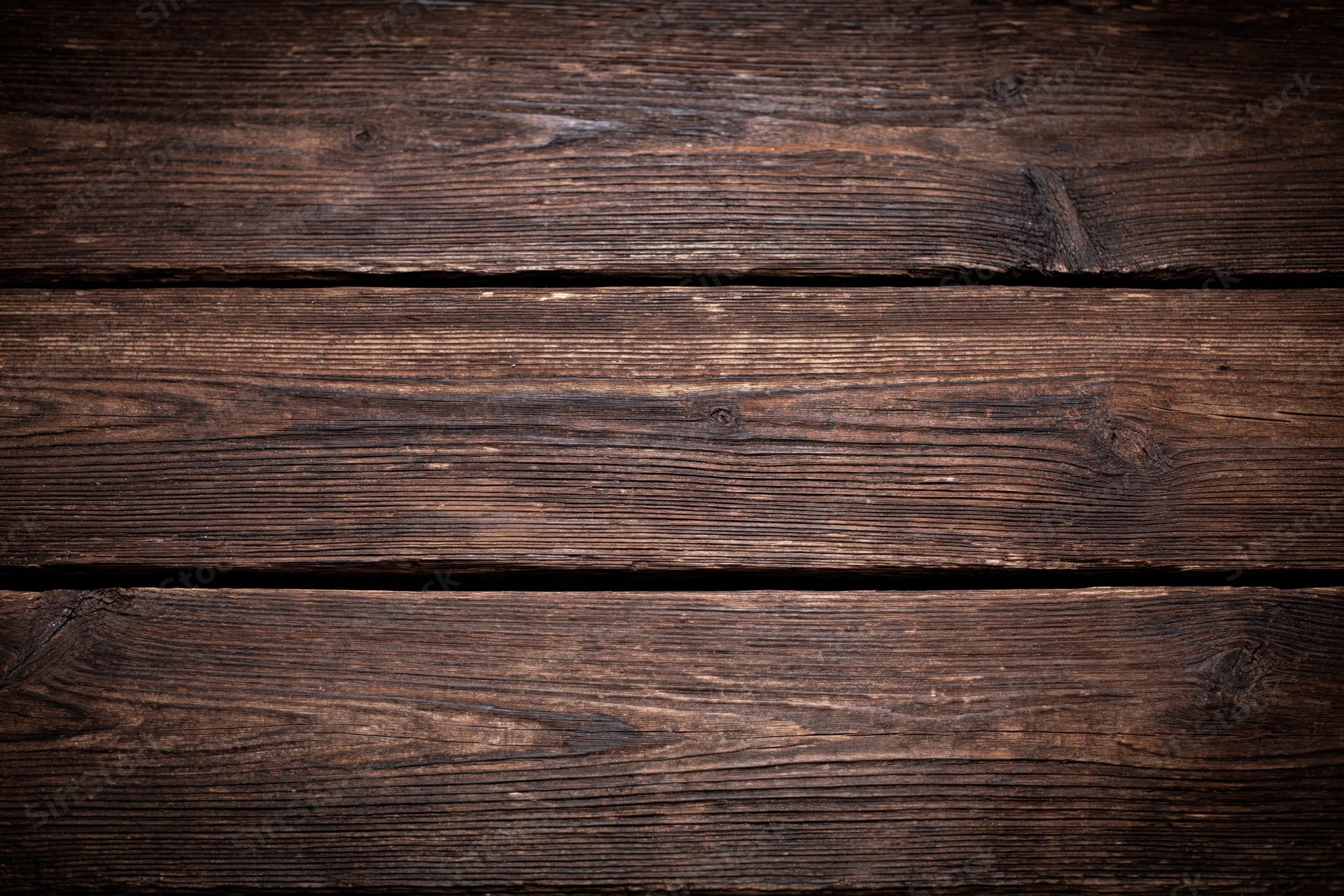 Close-up of dark aged wooden planks arranged horizontally as a textured surface