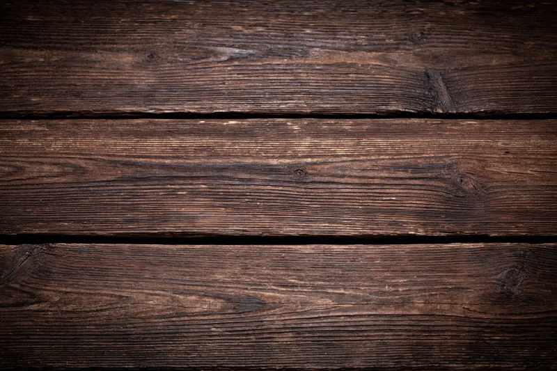 Close-up of dark aged wooden planks arranged horizontally as a textured surface
