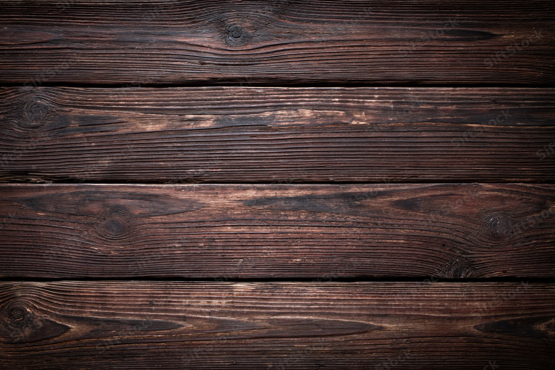Close-up of dark aged wooden planks arranged horizontally as a textured surface