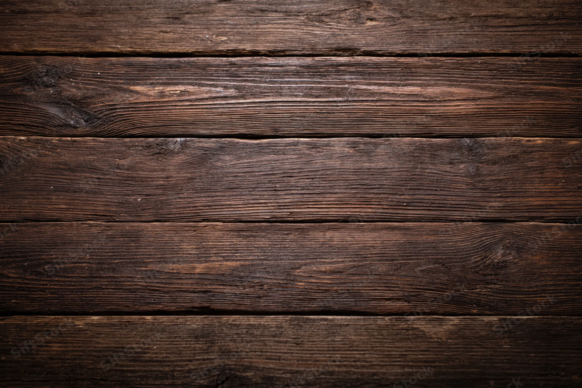 Close-up of dark aged wooden planks arranged horizontally as a textured surface