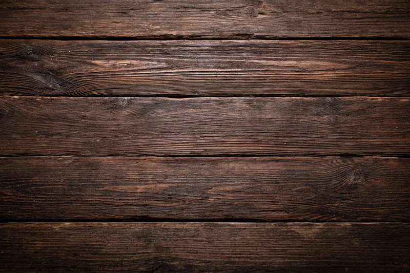 Close-up of dark aged wooden planks arranged horizontally as a textured surface
