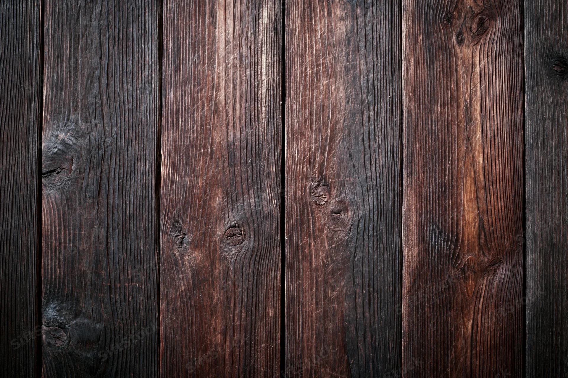 Close-up of dark aged wooden planks arranged vertically as a textured surface