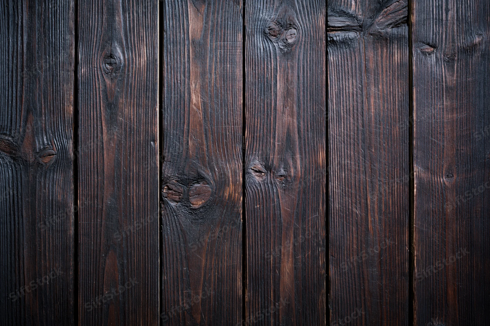 Close-up of dark aged wooden planks arranged vertically as a textured surface