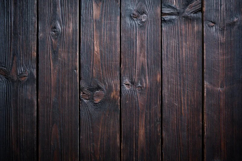 Close-up of dark aged wooden planks arranged vertically as a textured surface