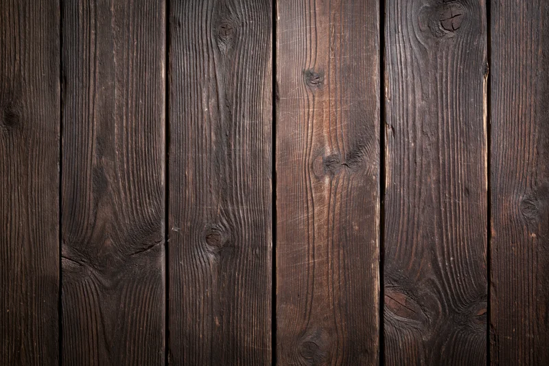 Close-up of dark aged wooden planks arranged vertically as a textured surface