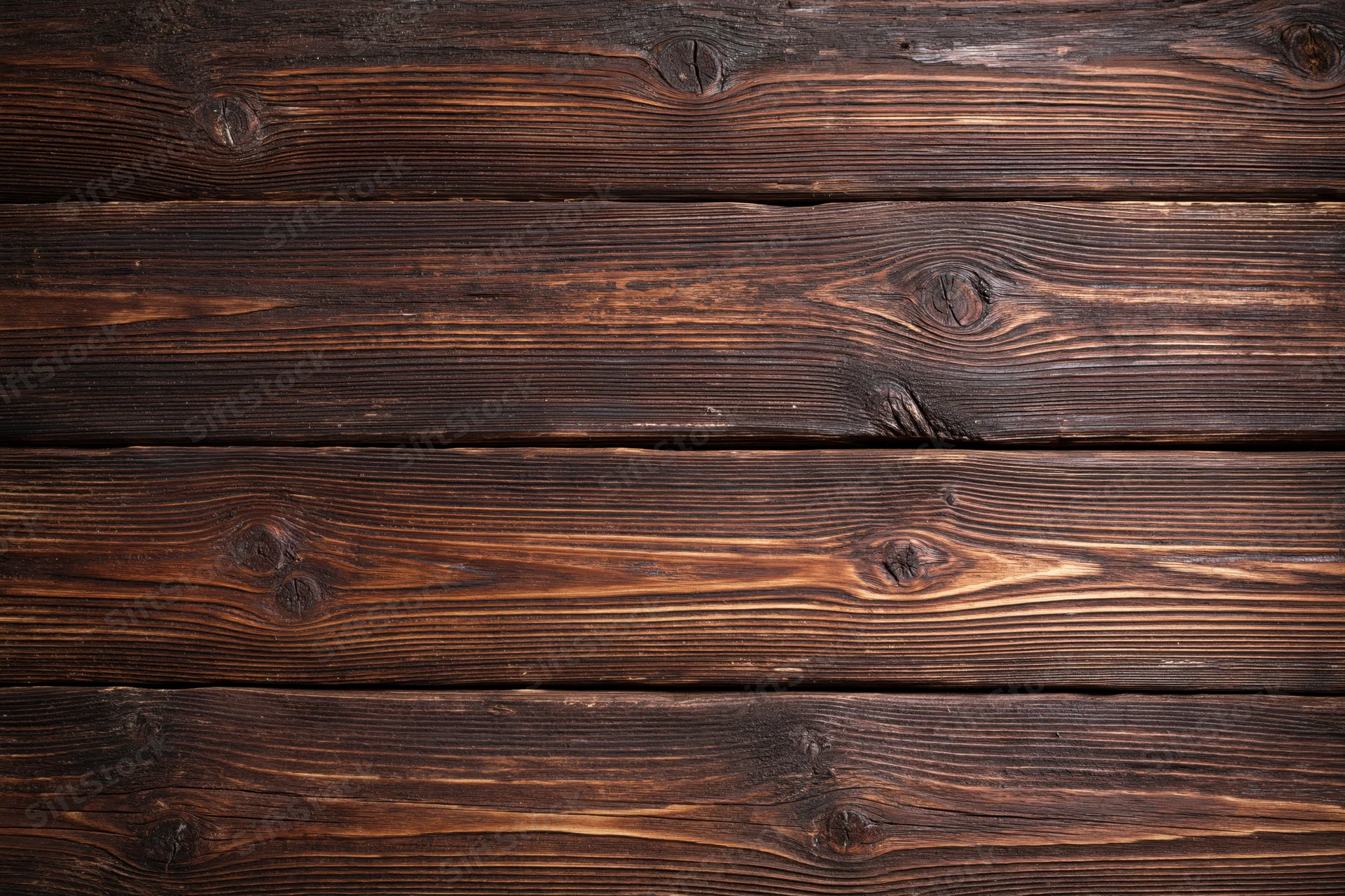 Close-up of aged horizontal wooden planks with visible grain and knots forming a rustic textured surface