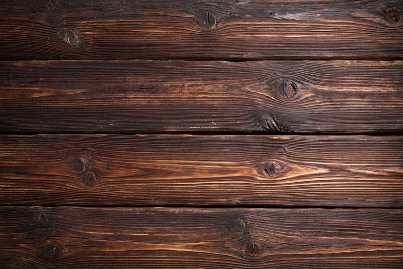 Close-up of aged horizontal wooden planks with visible grain and knots forming a rustic textured surface