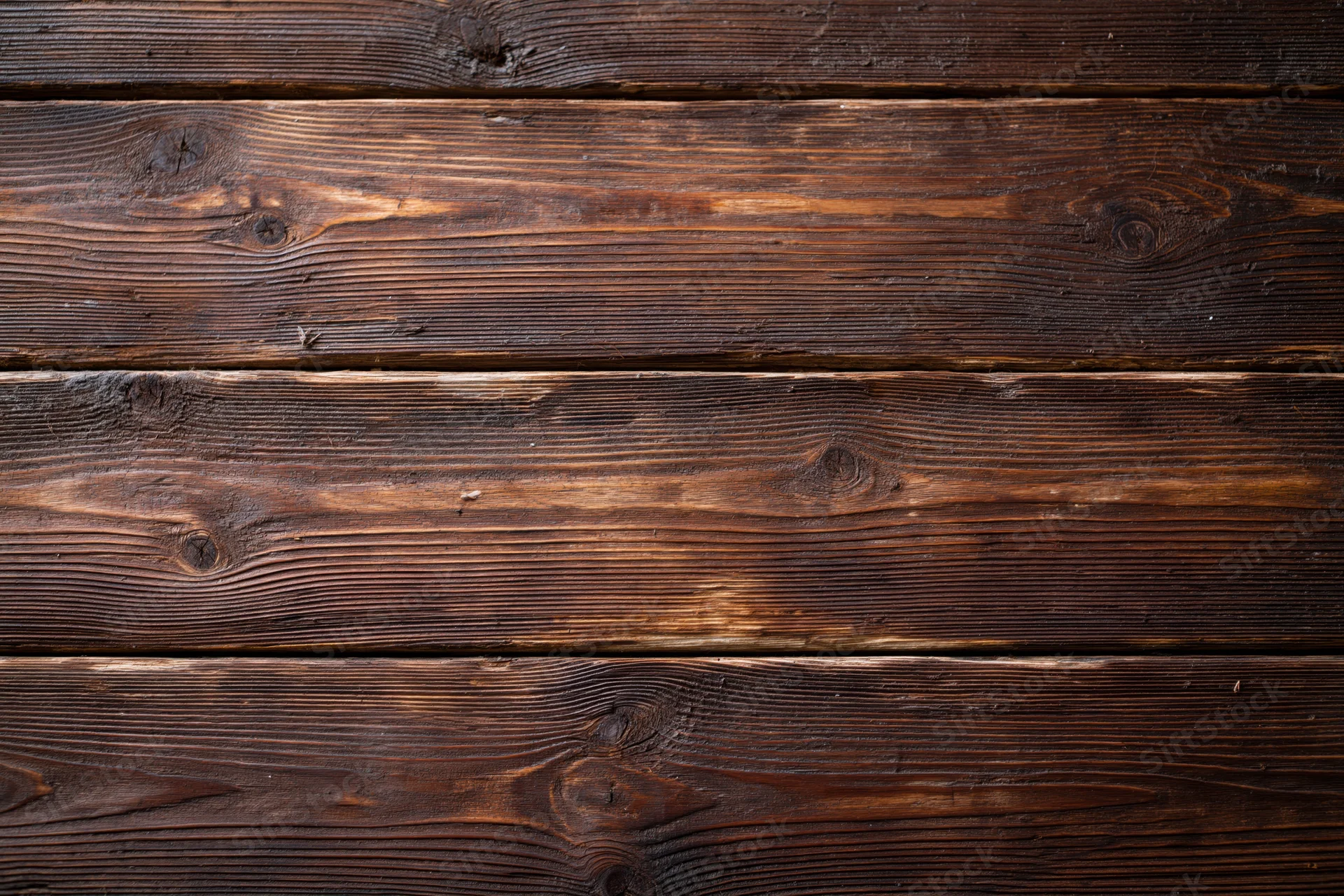 Close-up of aged horizontal wooden planks showing natural grain and knots as a textured surface