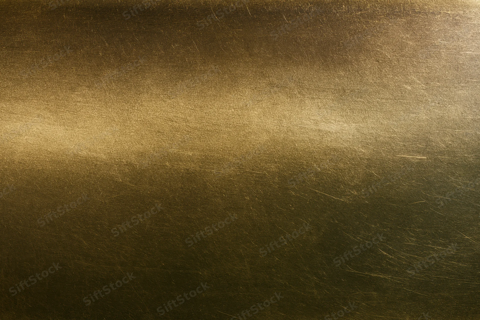 Close-up of an aged brass metal surface with brushed texture and warm patina
