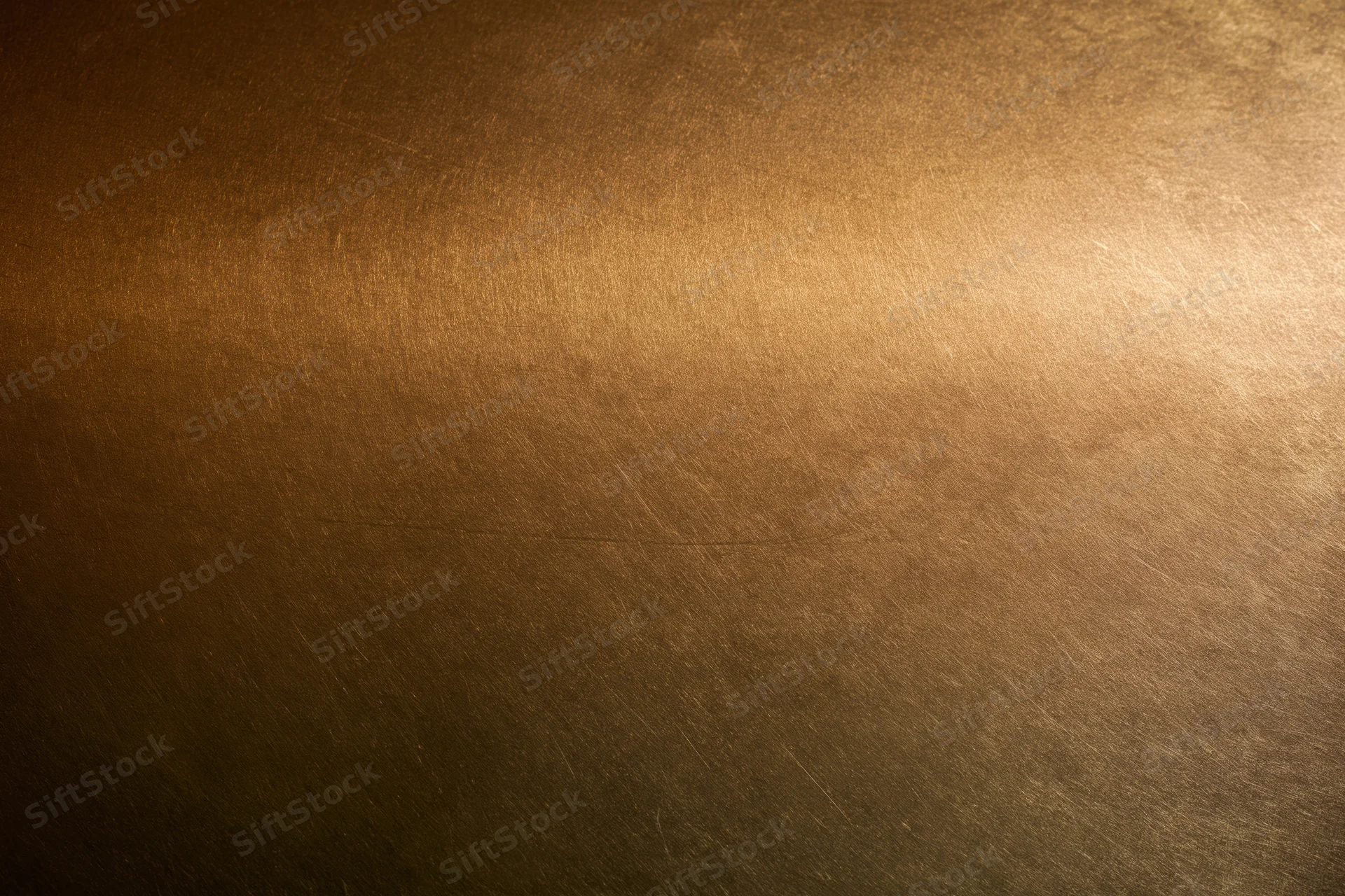 Close-up of an aged brass metal surface with visible texture and patina