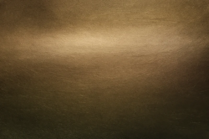 Close-up of an aged brass metal surface with textured patina and warm gradient lighting