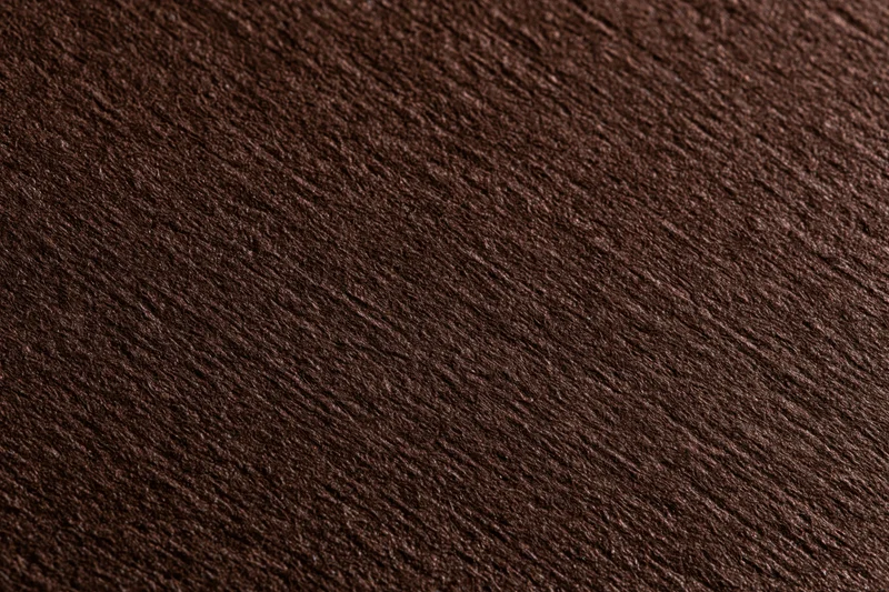 Close-up of dark brown textured cardstock paper surface in flat lay arrangement