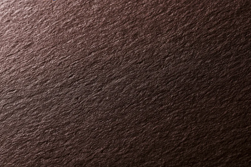 Close-up of dark brown textured cardstock paper surface in flat lay arrangement