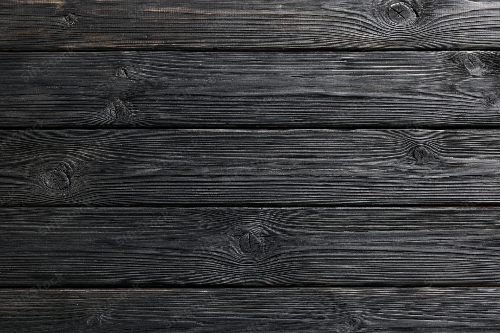 Dark charcoal-stained horizontal wooden planks with visible grain and knots forming a textured surface