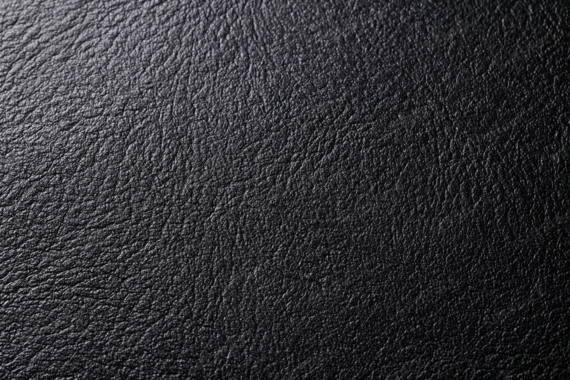 Close-up of dark charcoal black leather surface with visible grain and texture
