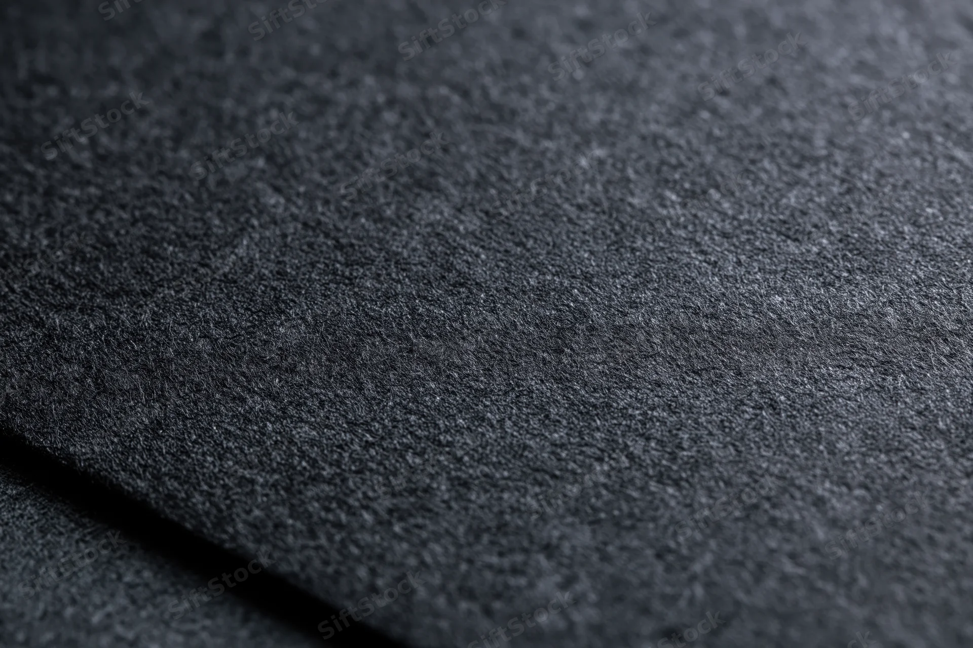 Close-up of dark charcoal black paper texture in flat lay arrangement