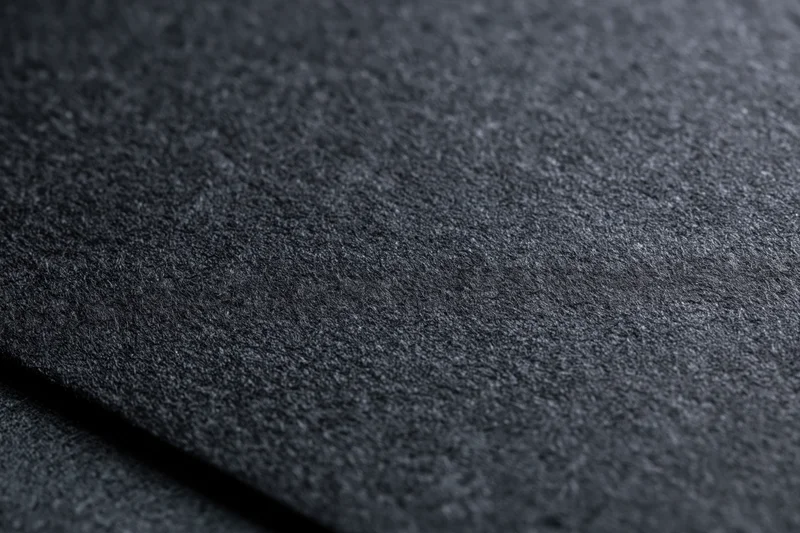 Close-up of dark charcoal black paper texture in flat lay arrangement