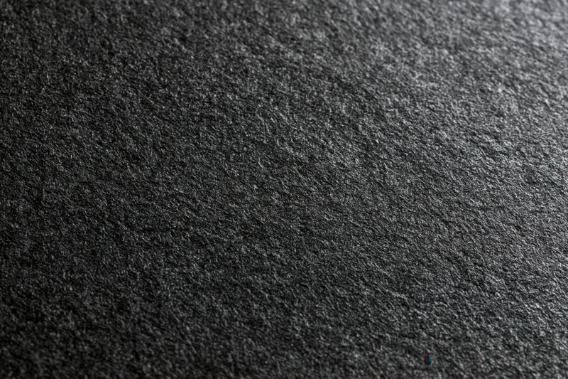 Close-up of dark charcoal black textured paper surface in flat lay arrangement