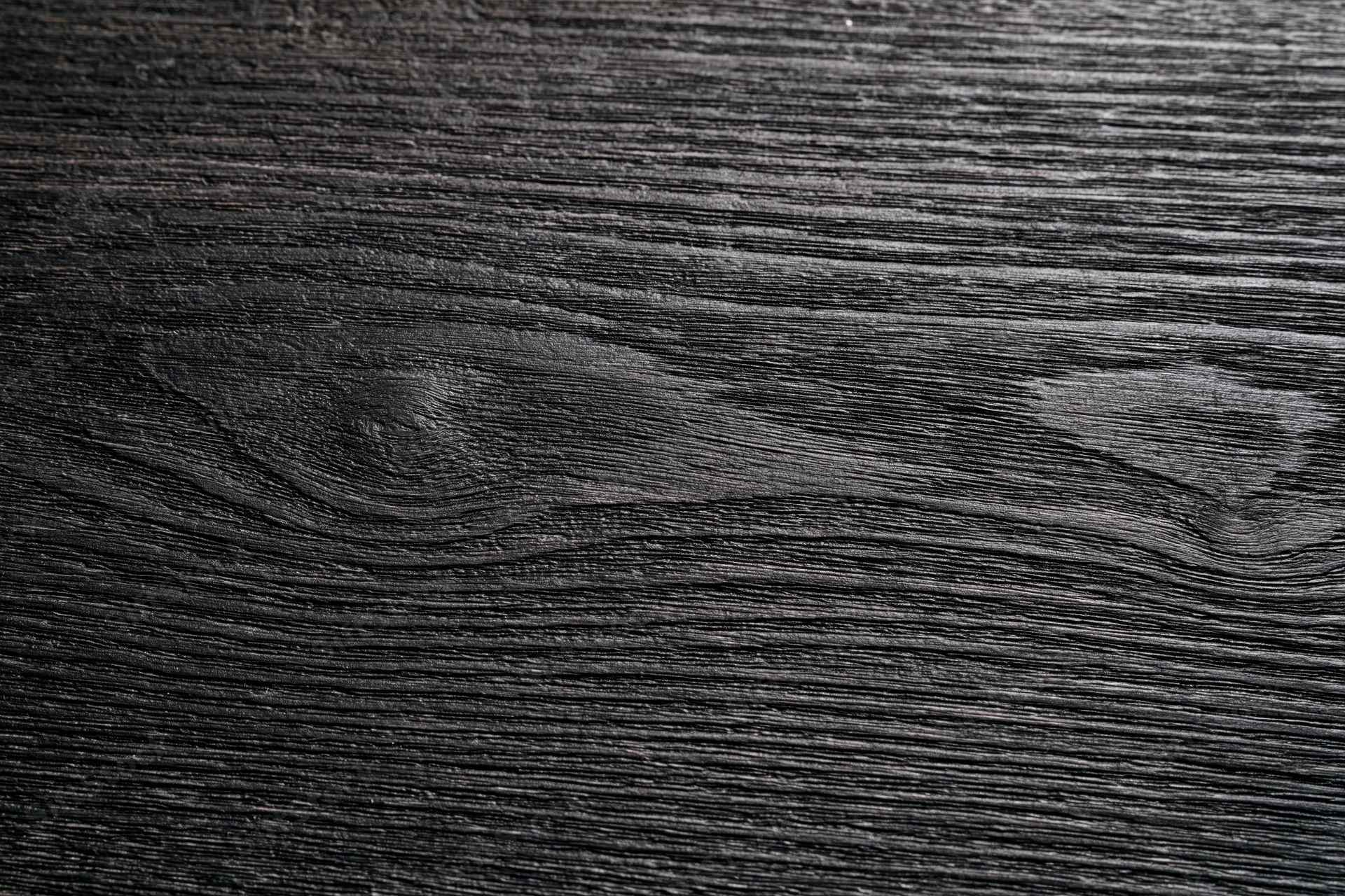 Close-up of dark charcoal wood surface showing natural grain texture