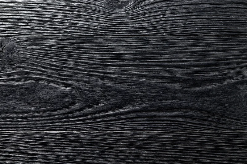 Close-up of dark charcoal wood surface showing natural grain and texture