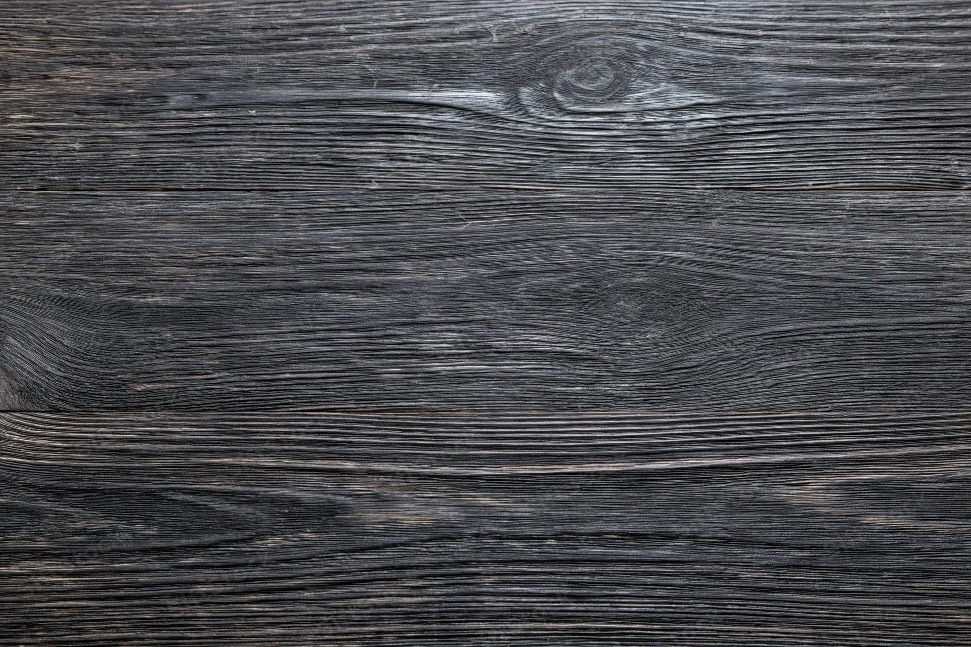 Close-up of dark charcoal wood surface showing natural grain and texture