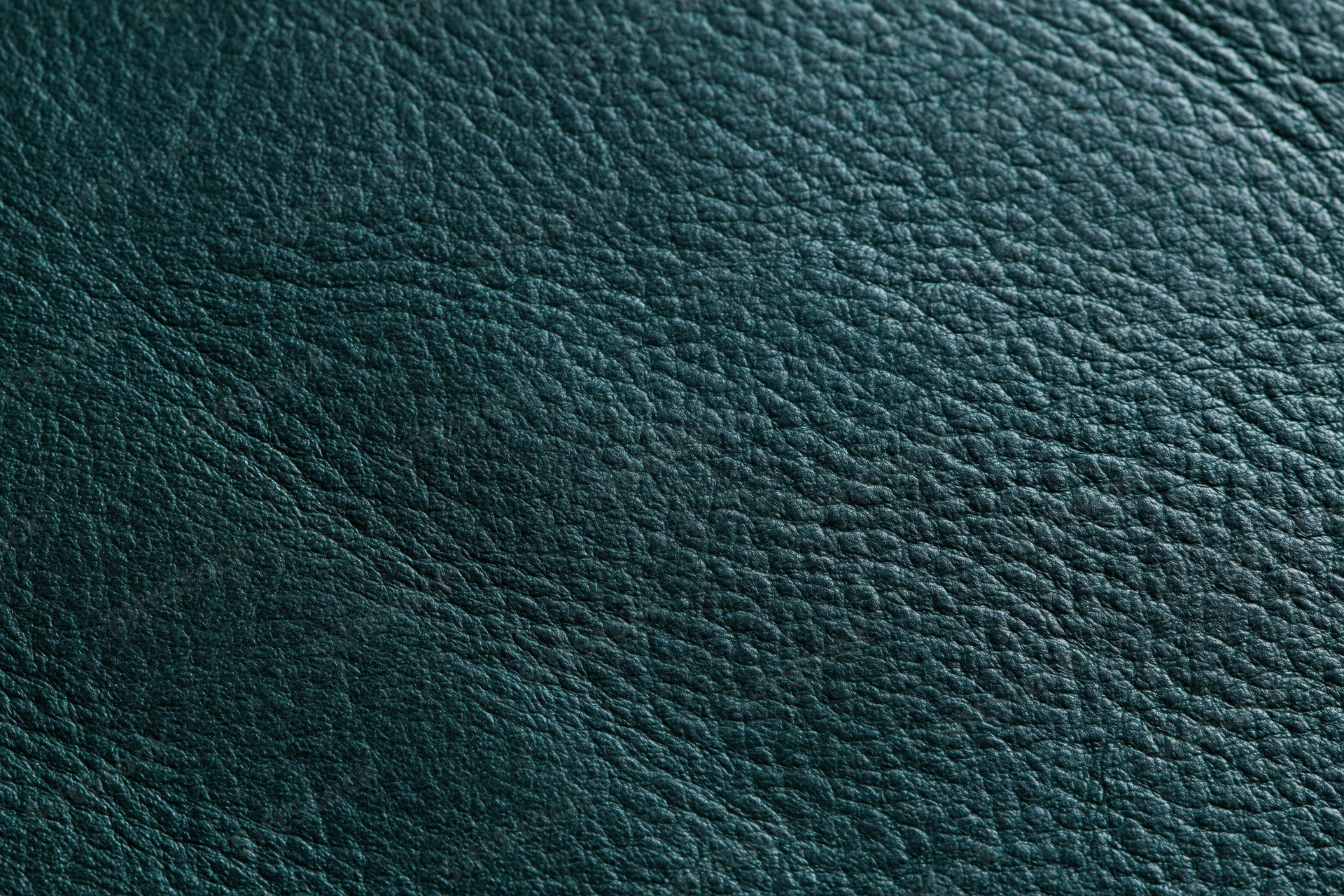 Close-up of dark forest green leather surface with pebbled texture filling the frame