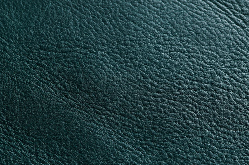 Close-up of dark forest green leather surface with pebbled texture filling the frame
