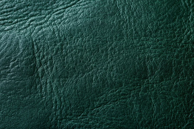 Close-up of dark forest green leather surface showing natural grain and texture
