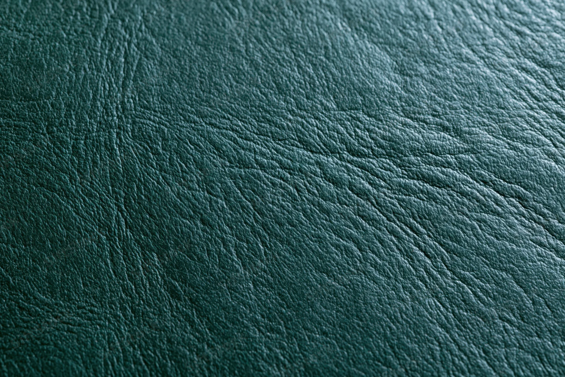 Close-up of dark forest green leather surface showing natural grain and texture