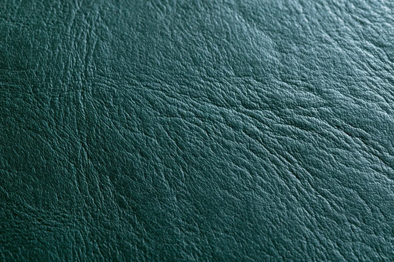Close-up of dark forest green leather surface showing natural grain and texture