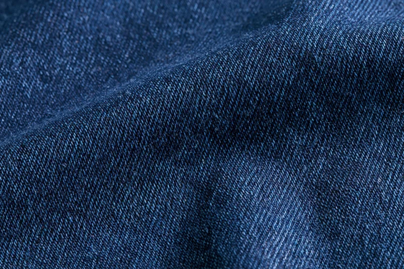 Close-up of dark indigo denim fabric with visible weave and texture
