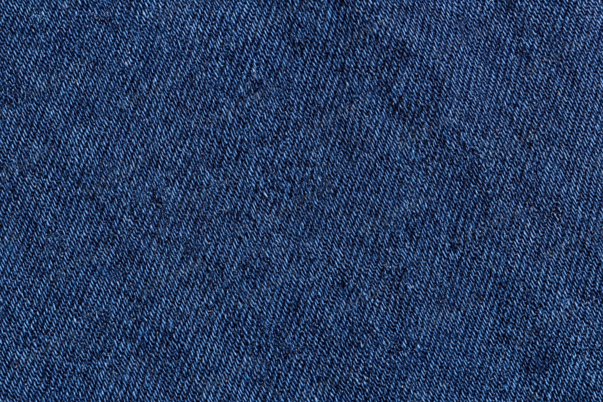 Close-up of dark indigo denim fabric with visible twill weave pattern